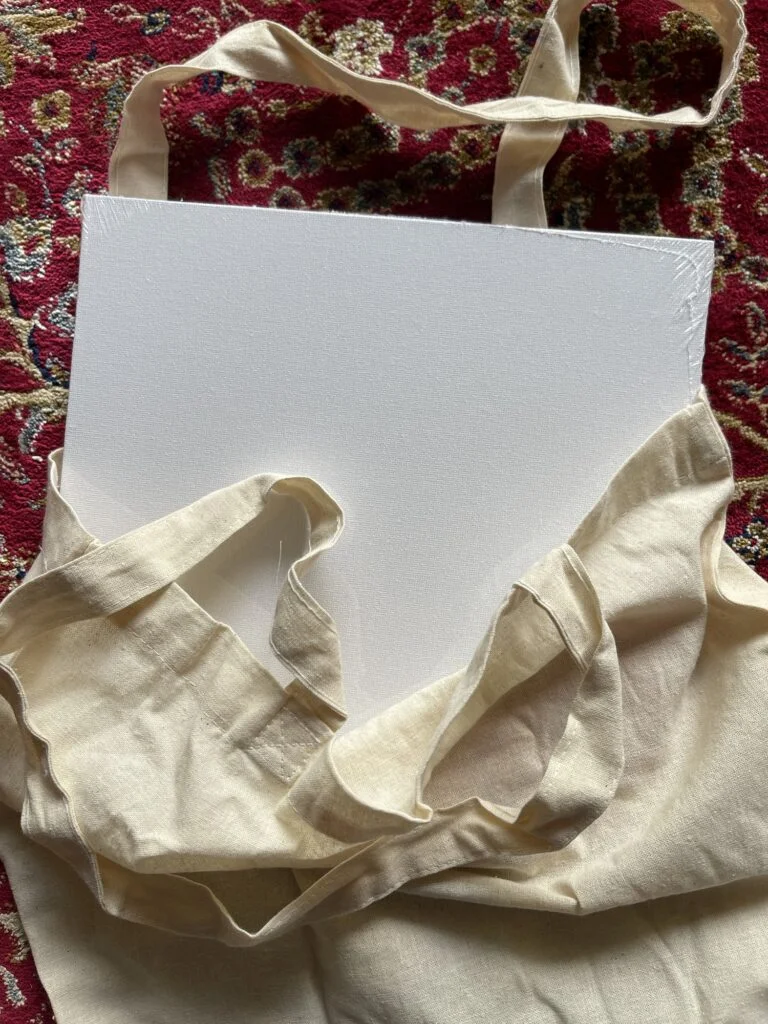 Bolso tote de lona planchado y preparado antes de pintar con un trozo de cartón en su interior