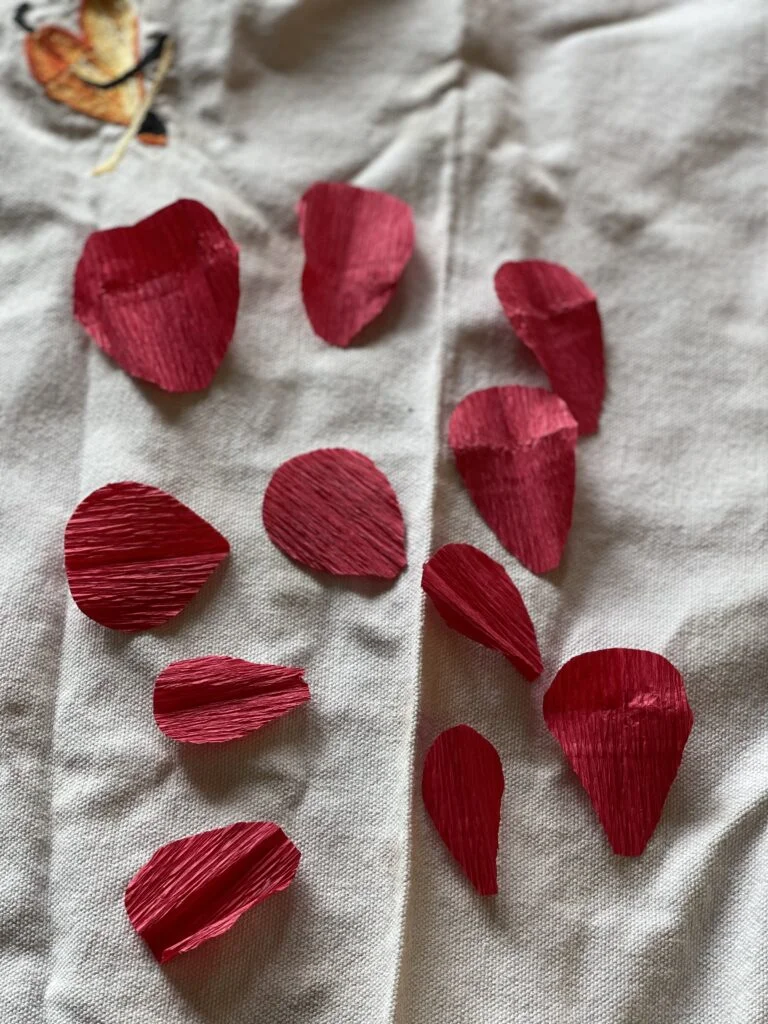 Pétalos individuales de papel crepé dispuestos listos para dar forma a los pétalos de rosa
