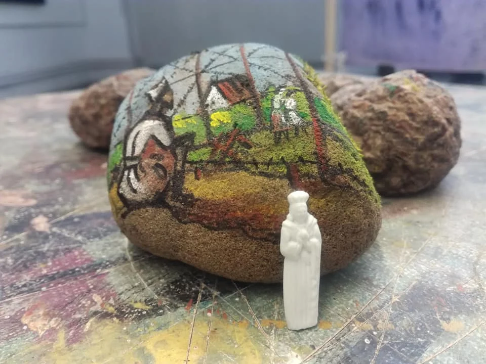 Colección de piedras con retratos de prisioneros dibujados, dispuestas sobre una superficie plana