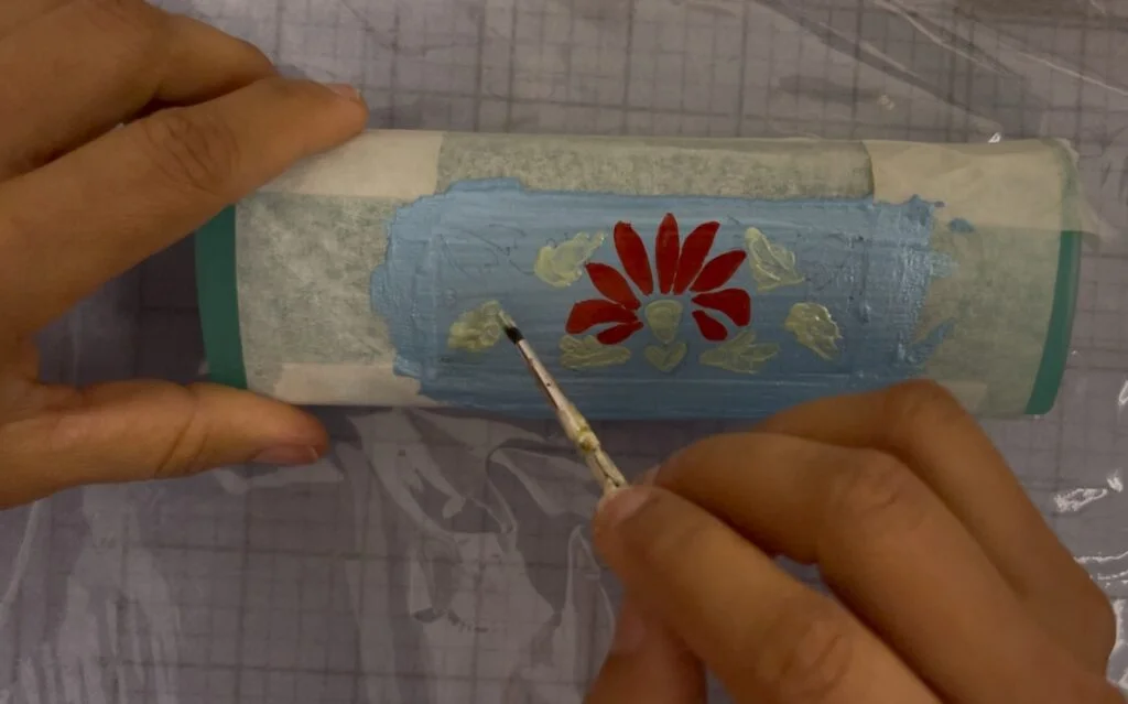 Boîte à lunettes optiques avec un motif coloré partiellement terminé, montrant le processus de peinture
