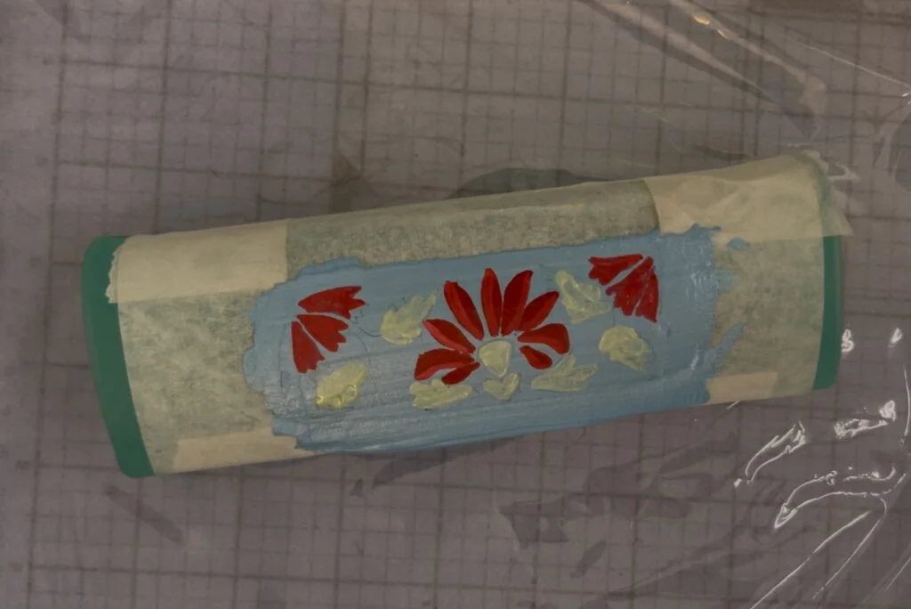 Peinture de motifs décoratifs avec un pinceau fin sur la boîte à lunettes pour une finition détaillée
