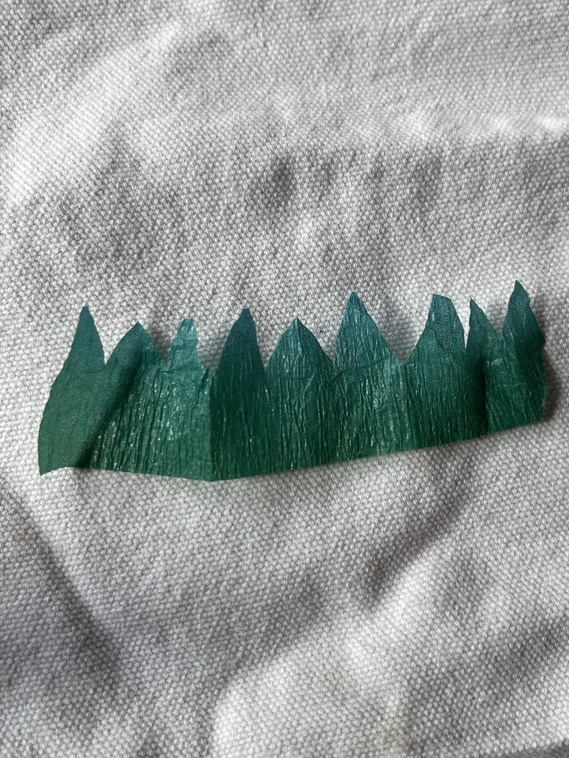 Feuilles en papier crépon vert découpées et façonnées avec du fil pour leur donner de la structure