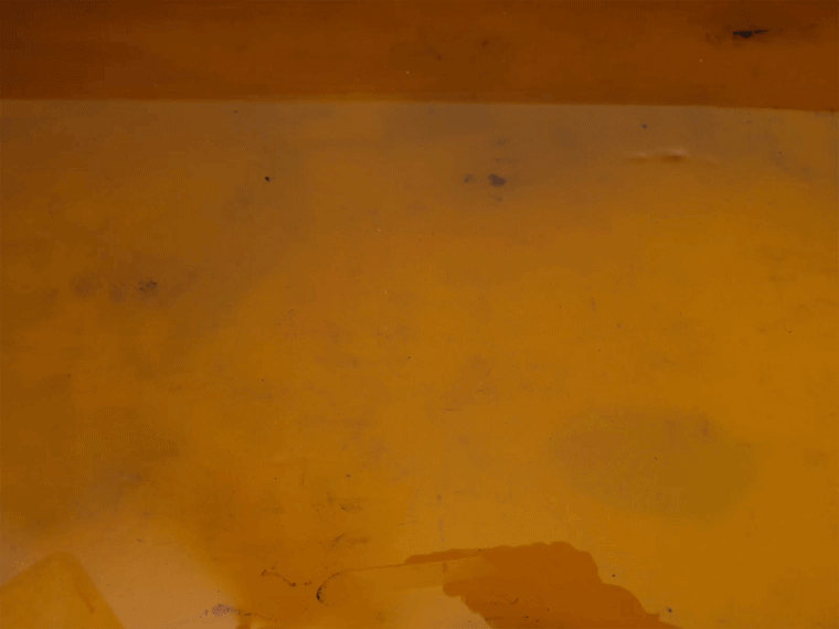 Diagram showing the acid bath step in etching where exposed metal is bitten by acid