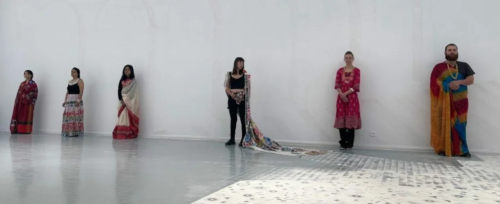 Textile sculpture made from cut beverage cans assembled like a sparkling garment, tribute to Bangladeshi women garment workers